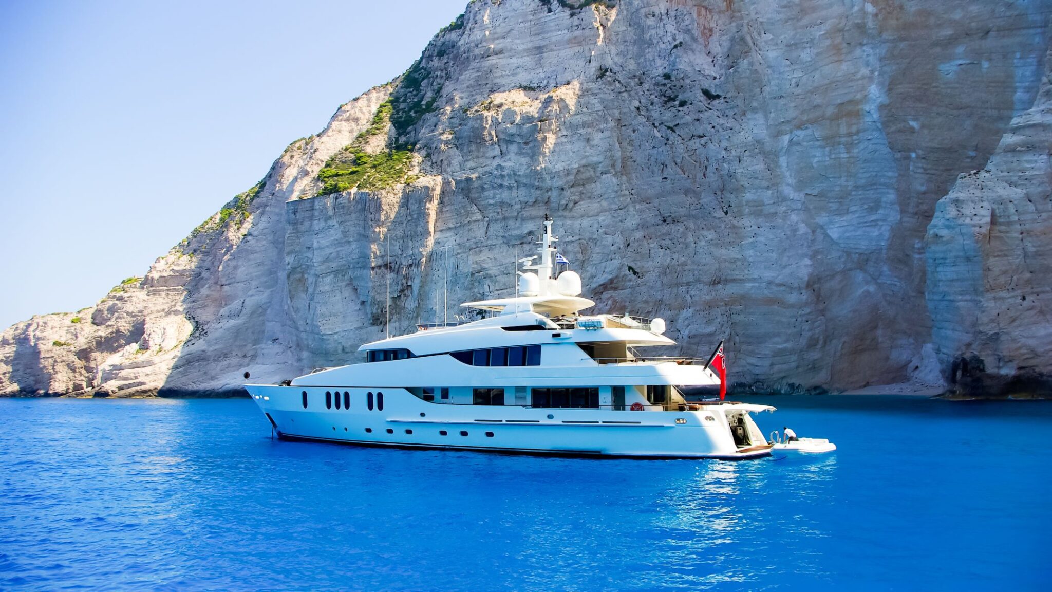 A motor yacht at anchor under the white cliffs of Zakynthos.